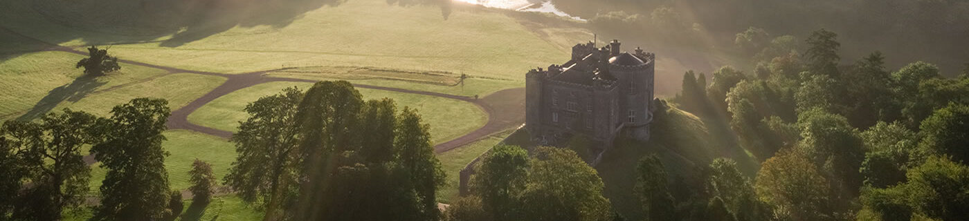 Slane Castle from above, green fields and sun rays