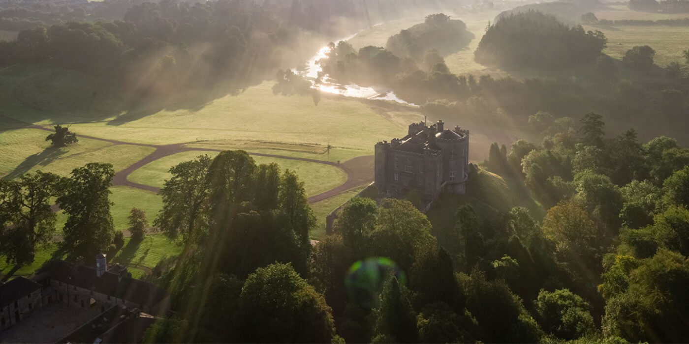 Slane Castle from above, green fields and sun rays