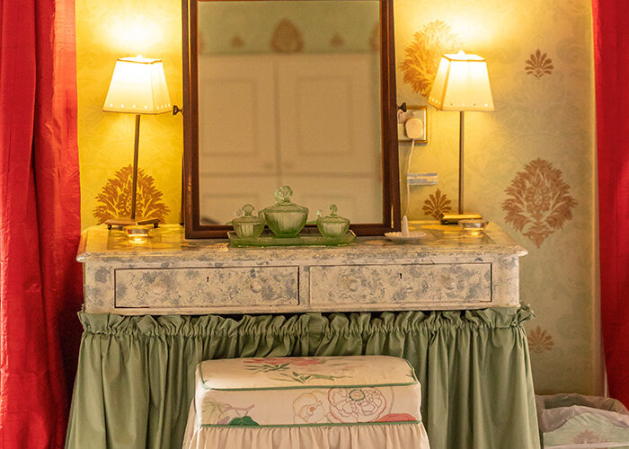 An old fashioned dressing table with lamps and a mirror