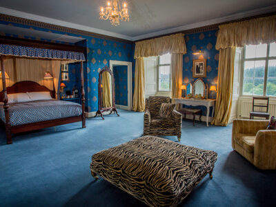 The Kings Room with four poster bed and comfy chairs