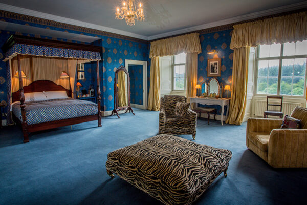 The Kings Room with four poster bed and comfy chairs