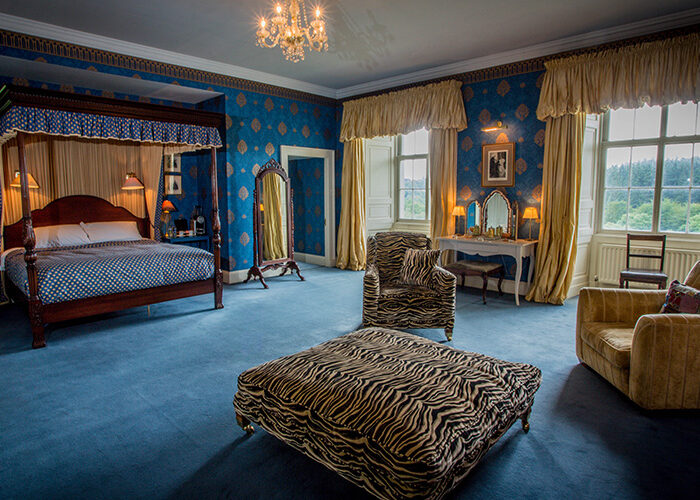 The Kings Room with four poster bed and comfy chairs