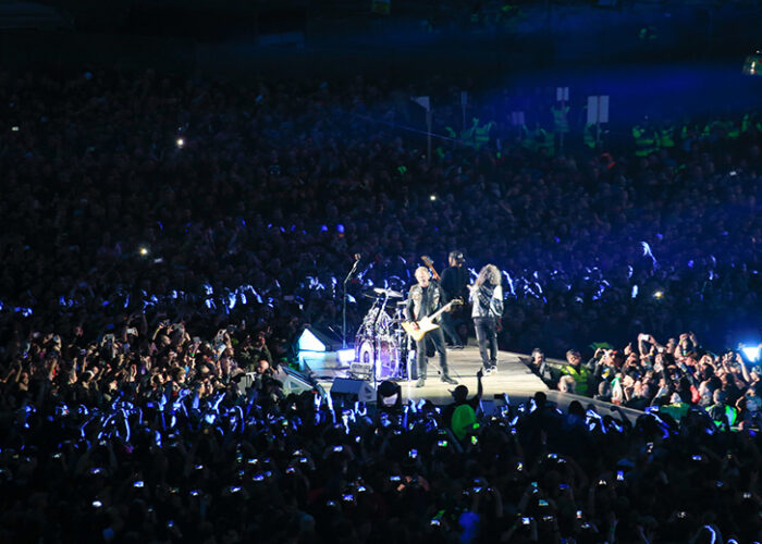 Metallica on stage surrounded by a crowd