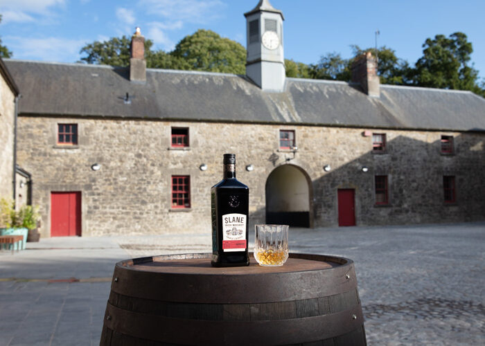 Slane Whiskey bottle on a barrel outside the distillery building