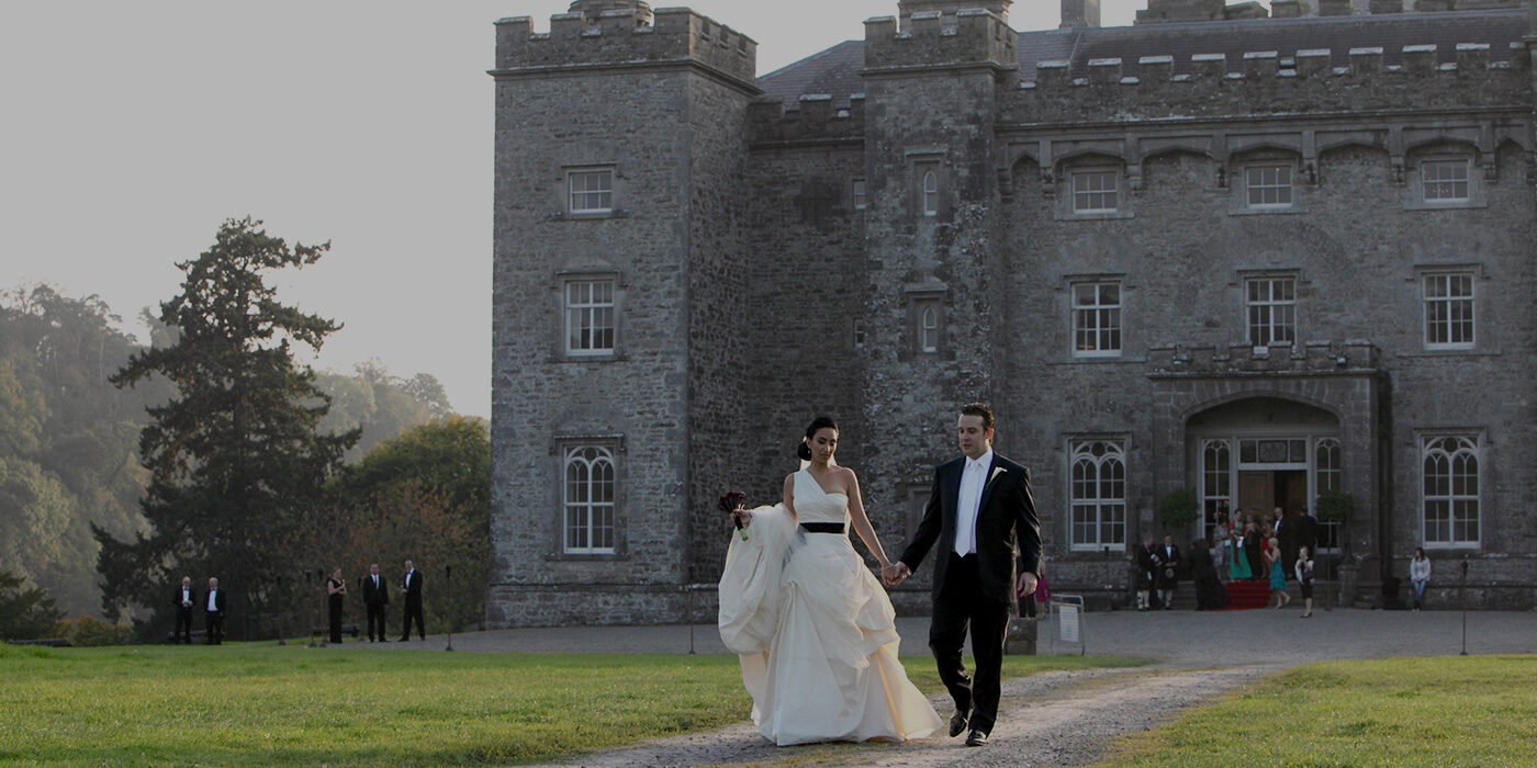 A wedding couple walking away from the castle