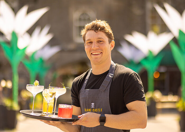 Waiter holding a tray of cocktails outside