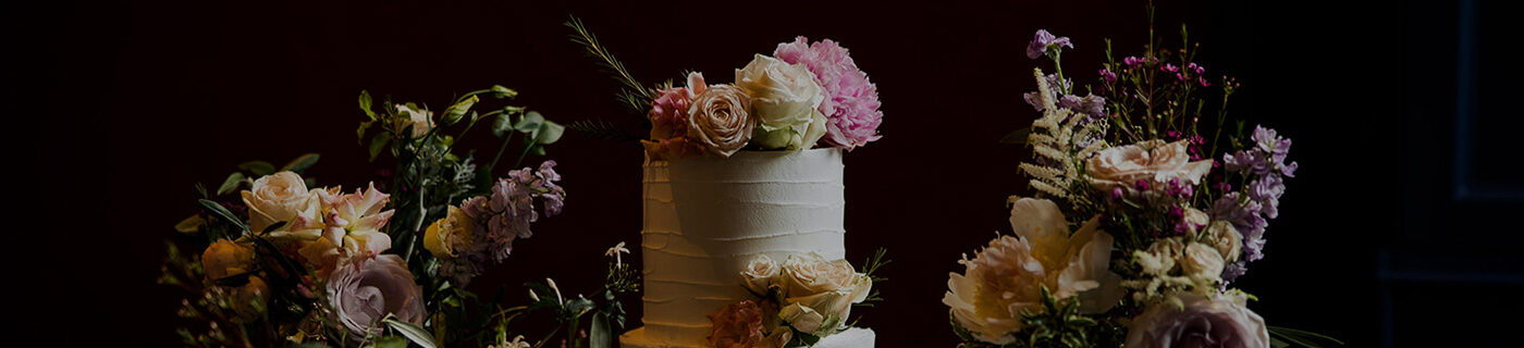 A wedding cake topped with fresh flowers