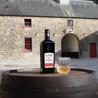 Slane Whiskey and Glass on a barrel
