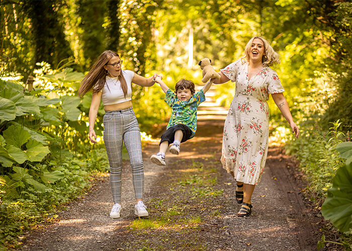 Two women swinging a child on the Slane Walking Trail