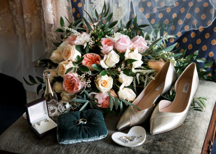 Wedding flowers on a chair with shoes and rings