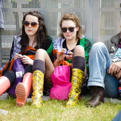 Three people sitting on grass resting at Slane Concert