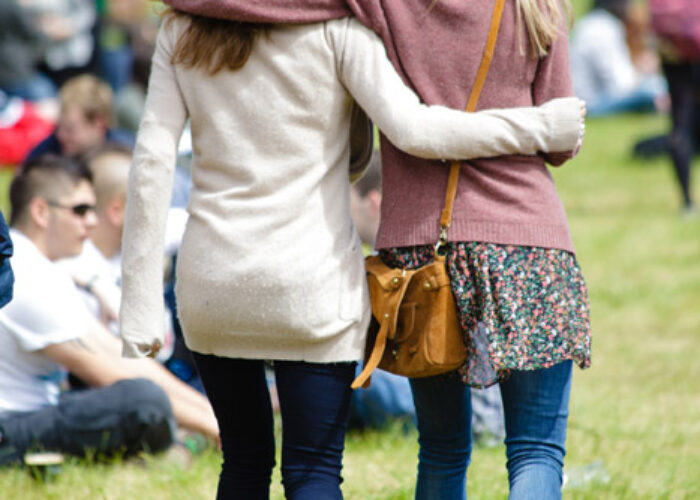 Two girls arm in arm walking through Slane Castle Concert