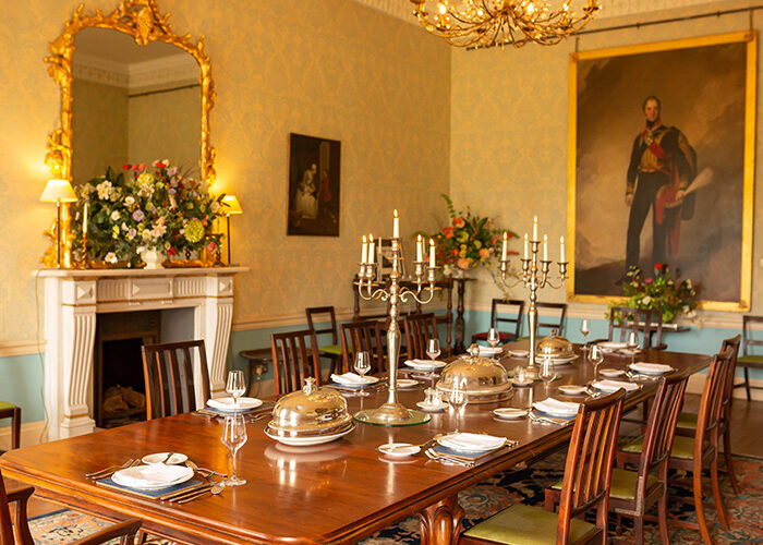 A dining room with portraits on the walls