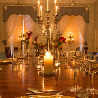 A dining table set with candles and glasses