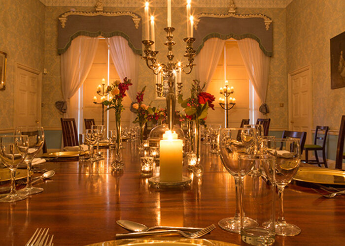 A dining table set with candles and glasses