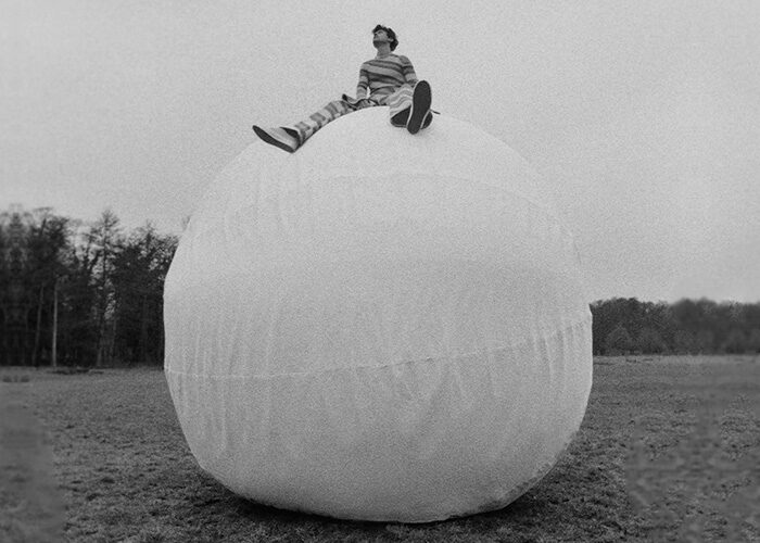 Harry Styles sitting on a big white inflatable